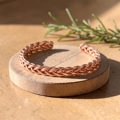 Ella's Clay braided copper cuff on a wooden disc