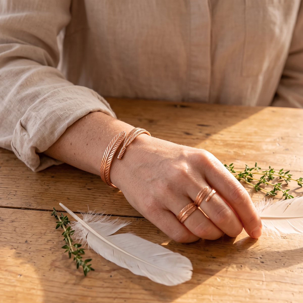 Feather cuff and ring worn together by a woman