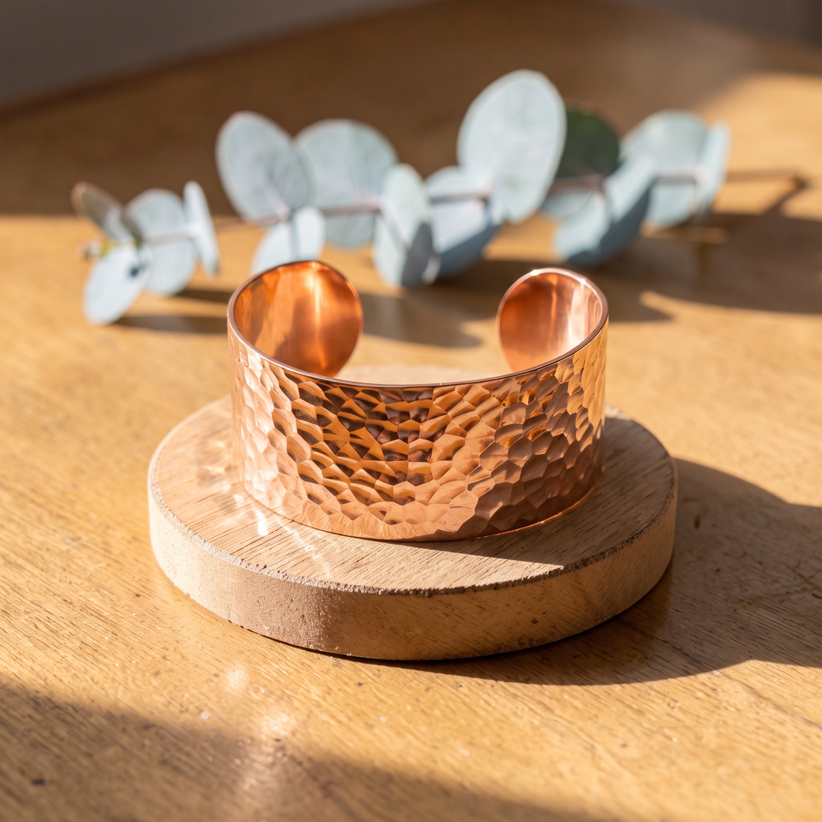 Ella's Ocean hammered copper cuff on a wooden disc