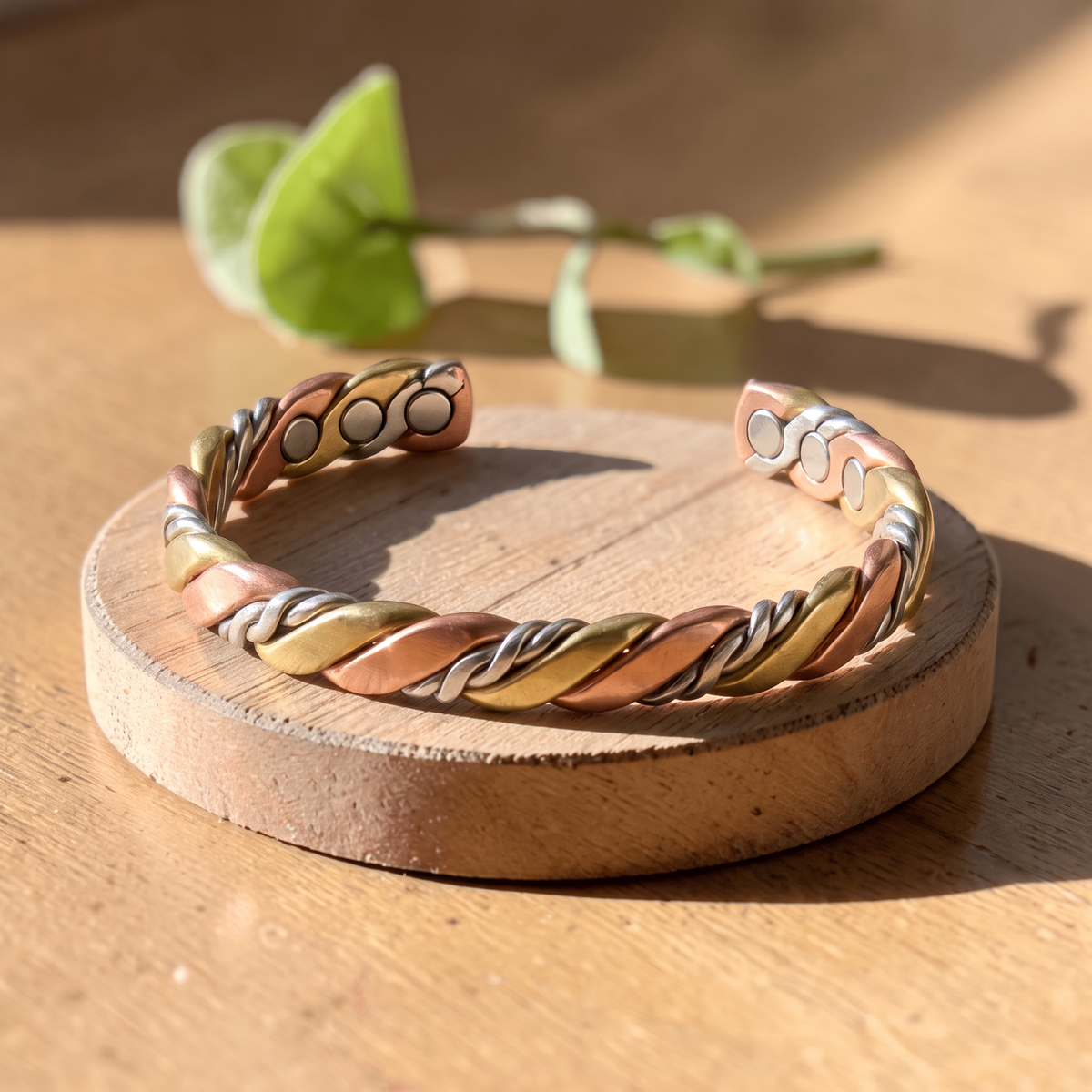 Ella's Evora twisted copper and brass bracelet on a wooden disc