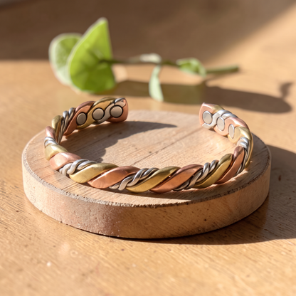Ella's Evora twisted copper and brass bracelet on a wooden disc