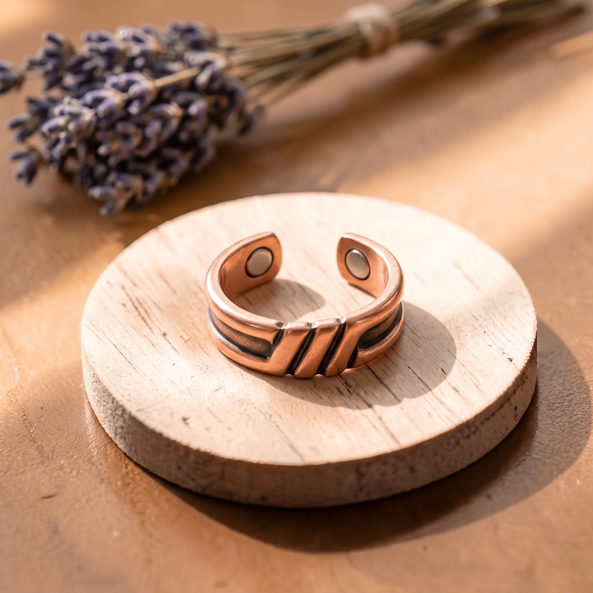Ella's Oriana copper ring on a wooden disc