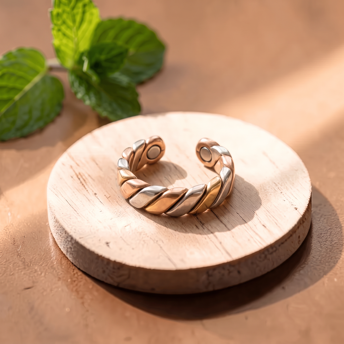 Ella's Evora tri-metal adjustable ring on a wooden disc
