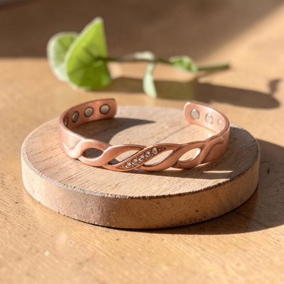 Ella's Elysia copper bracelet with crystals on a wooden disc
